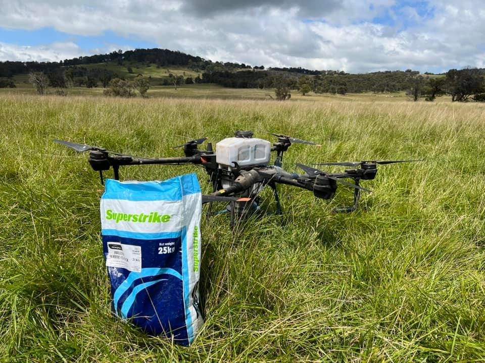Drone in paddock next to seed bag